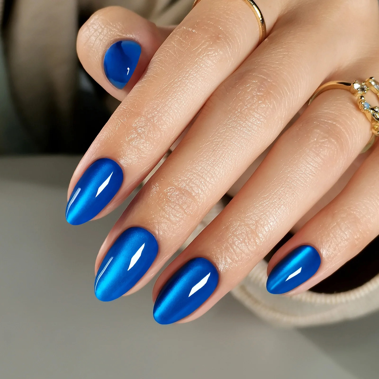 Almond nails finished in glossy cobalt-blue chrome